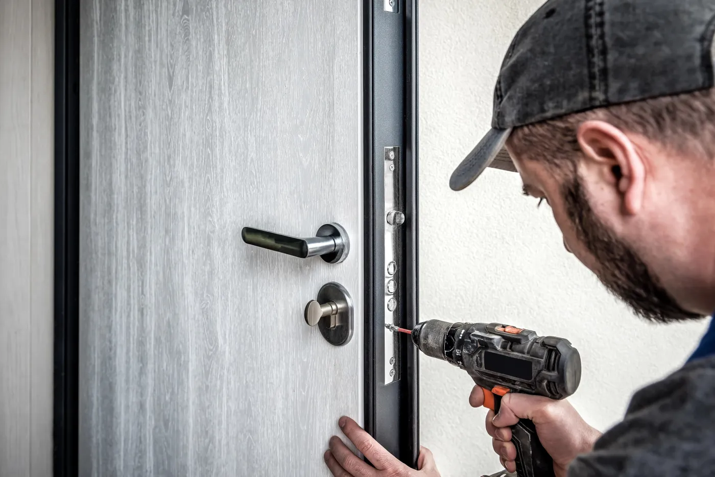 Artisan renforçant une porte palière dans un immeuble du 14e arrondissement de Paris